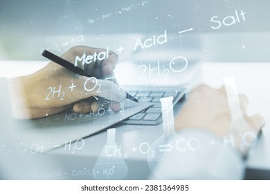 Double exposure of creative chemistry concept with hand writing in notebook on background with laptop, research and development concept