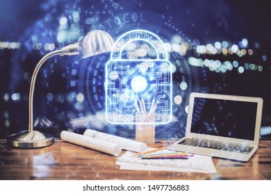 Double exposure of desktop with computer and lock icon hologram. Concept of data safety.