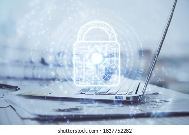 Double exposure of desktop with computer and lock icon hologram. Concept of data safety.
