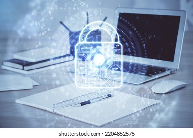 Double exposure of desktop with computer and lock icon hologram. Concept of data safety.