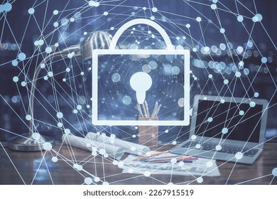 Double exposure of desktop with computer and lock icon hologram. Concept of data safety.