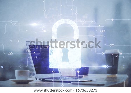 Double exposure of desktop with computer and lock icon hologram. Concept of data safety.