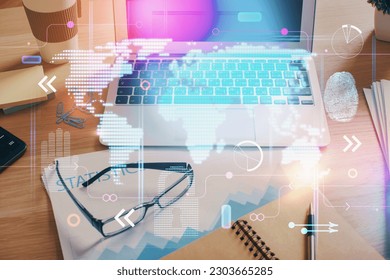 Double exposure of desktop with computer and world map hologram. International data network concept.