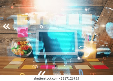 Double exposure of desktop with computer and world map hologram. International data network concept.