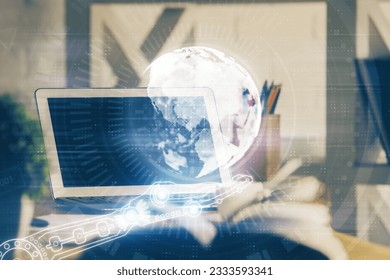 Double exposure of desktop with computer and world map hologram. International data network concept.