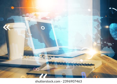 Double exposure of desktop with computer and world map hologram. International data network concept.