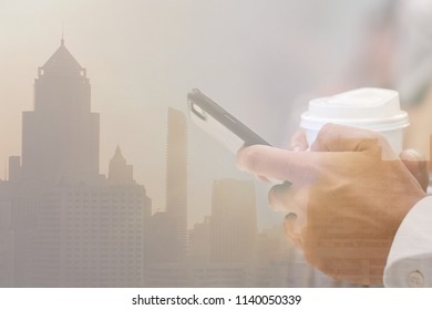 Double exposure with development city background. Copy space and Closeup hand  holding the mobile phone and a cup of coffee. Concept of businessman , Technology.