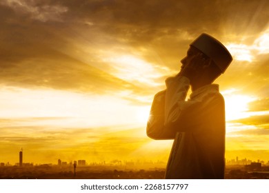 Double exposure of devout man doing azan while standing with city background