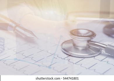 Double Exposure Of Doctor Workplace With A Stethoscope At Wooden Table,Cardiogram Chart With Medical Stethoscope And Finances Statement With Pen,Finance Business,discussing On Stock Market Charts 