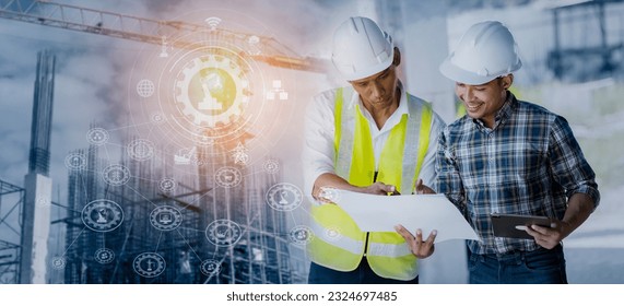 Double exposure engineering team using tablet computer and digital technology interfaces icon on construction cranes background, Technology and business industrial concept.