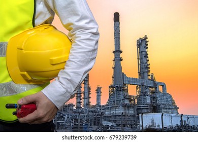 Double Exposure Engineers Industry Worker Holding Safety Helmet In Arms And Holding Walk Talky In Hands With Oil And Gas Refinery Background On Industry Concept,Pipelines And Petrochemical Plant