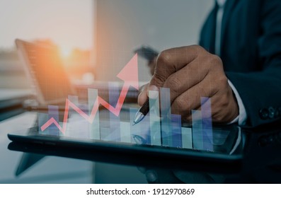 Double exposure of financial graph. Stock market chart. Businessman hand using tablet and stock market or forex graph, Forex investment business internet technology concept, blurred background. 