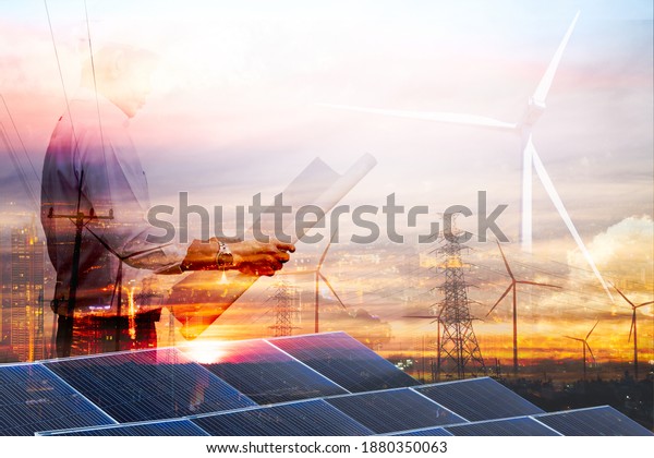 Double\
exposure graphic of business people working over wind turbine farm\
and green renewable energy worker interface. Concept of\
sustainability development by alternative\
energy.