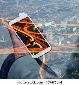 Double exposure of hand touch screen on smartphone. City concept.