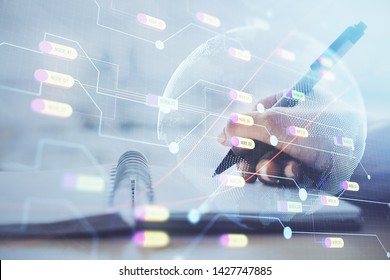 Double exposure of hands making notes with world map hologram and data theme icons. Concept of global computer data.