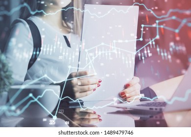 Double exposure of hands making notes with forex chart huds. Stock market concept.