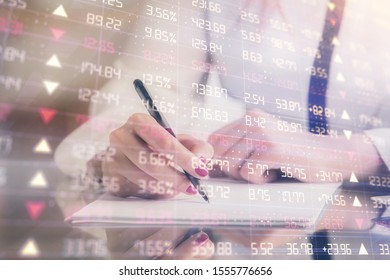 Double exposure of hands making notes with forex chart huds. Stock market concept.