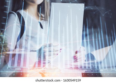 Double exposure of hands making notes with forex chart huds. Stock market concept.