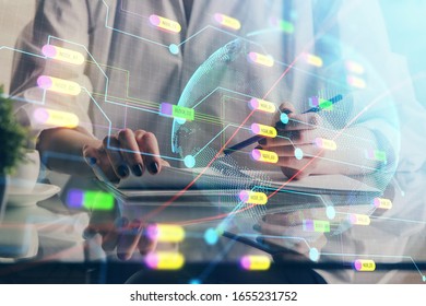 Double exposure of hands making notes with world map hologram and data theme icons. Concept of international network data.