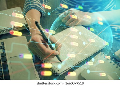 Double exposure of hands making notes with world map hologram and data theme icons. Concept of international network data.