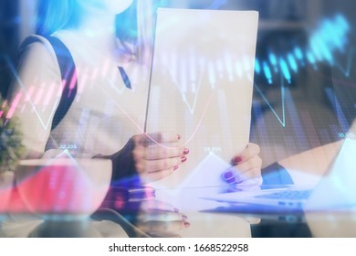 Double exposure of hands making notes with forex chart huds. Stock market concept.