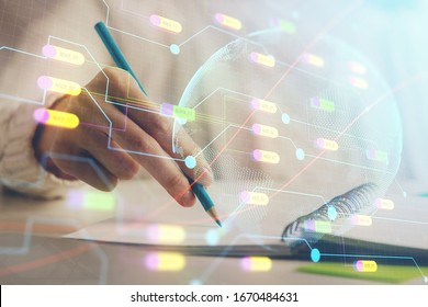 Double exposure of hands making notes with world map hologram and data theme icons. Concept of international network data.