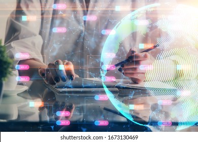 Double exposure of hands making notes with world map hologram and data theme icons. Concept of international network data.