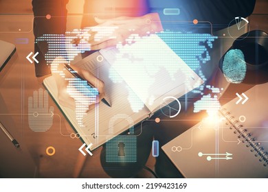 Double exposure of hands making notes with world map hologram and data theme icons. Concept of global computer data.