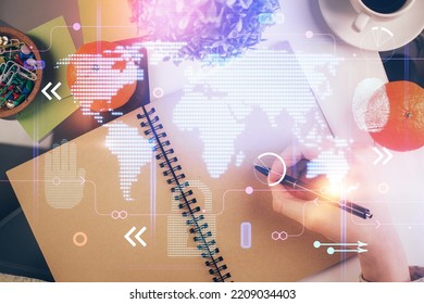 Double exposure of hands making notes with world map hologram and data theme icons. Concept of global computer data.