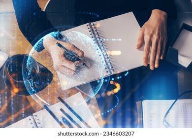 Double exposure of hands making notes with world map hologram and data theme icons. Concept of global computer data.