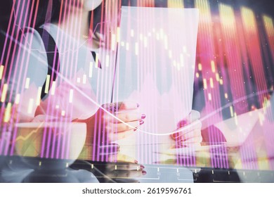 Double exposure of hands making notes with forex chart huds. Stock market concept.