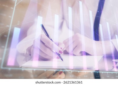 Double exposure of hands making notes with forex chart huds. Stock market concept.