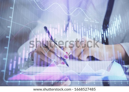 Double exposure of hands making notes with forex chart huds. Stock market concept.