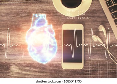 Double exposure of heart drawing over table with phone. Top view. Medical education concept.