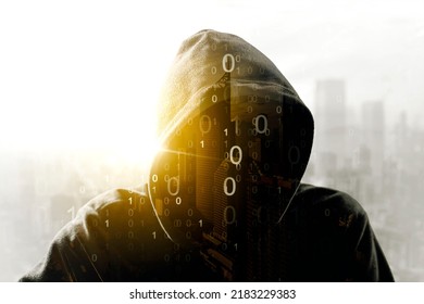 Double exposure of hooded hacker with binary code in cityscape background