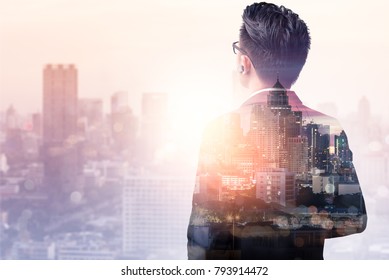 The Double Exposure Image Of The Business Man Standing Back During Sunrise Overlay With Cityscape Image. The Concept Of Modern Life, Business, City Life And Internet Of Things.