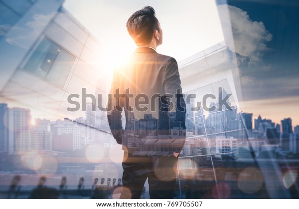 The double\
exposure image of the business man standing back during sunrise\
overlay with cityscape image. The concept of modern life, business,\
city life and internet of\
things.
