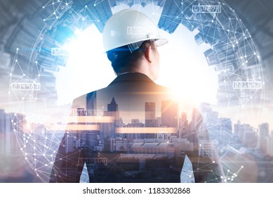 The double exposure image of the engineer standing back during sunrise overlay with cityscape image and futuristic hologram. The concept of engineering, construction, city life and future.