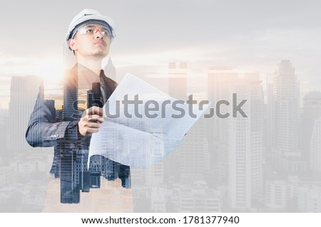 The double exposure image of the engineer standing back during sunrise overlay with cityscape image. The concept of engineering, construction, city life and future.