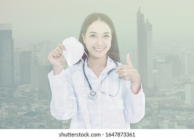 Double Exposure  Images Of Asian Woman Doctor Holding A Mask And Use Her Hand To Make A Great Symbol, Concept To Health Care And Primary Disease Prevention, Such As PM 2.5 And Coronavirus