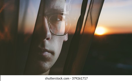 Double exposure of the man and sun in curtains
