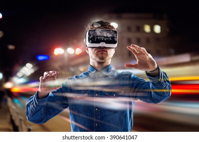 Double exposure, man wearing virtual reality goggles, night city