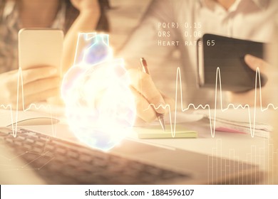 Double exposure of man and woman working together and human heart hologram drawing. Medical education concept. Computer background.