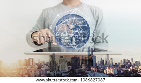 Double exposure, a man working on digital tablet and global network connection hologram technology. Element of this image are furnished by NASA