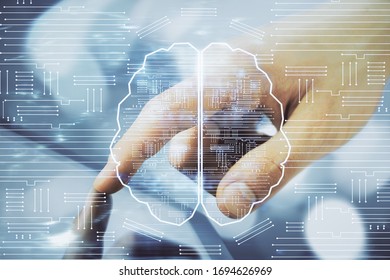 Double exposure of man's hand holding and using a digital device and brain hologram drawing. Data concept.
