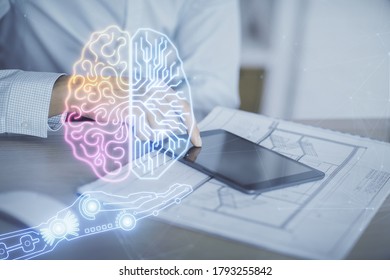 Double exposure of man's hand holding and using a digital device and brain hologram drawing. Data concept.