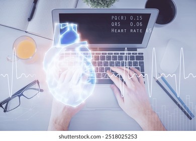 Double exposure of man's hands typing over computer keyboard and human heart hologram drawing. Top view. Medical education concept. - Powered by Shutterstock