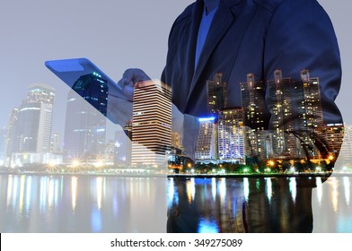 Double Exposure Of Night City And Business Man Using Digital Tablet Device As Business Development Concept.