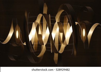 Double exposure photo of lighting fixture with spiral / ribbon structure in mysterious backlight. Realistic though unreal modern architecture / interior detail