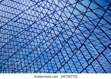 Double exposure photo of modern architecture fragment with structural glazing. Glass wall, ceiling or roof made of transparent panels. Abstract geometric background with checkered or grid pattern.